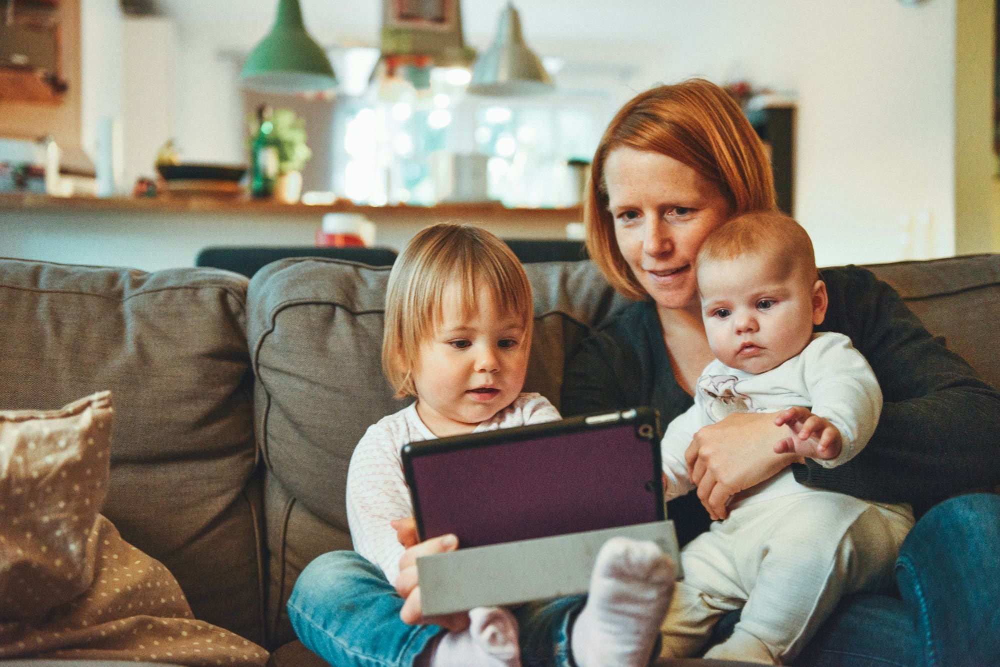 Mère et ses deux jeunes enfants dans le canapé